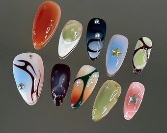 May include: A collection of ten different nail art designs. The designs include abstract patterns, swirls, stars, and glitter. The nails are painted in various colors, including white, black, blue, green, red, and pink.