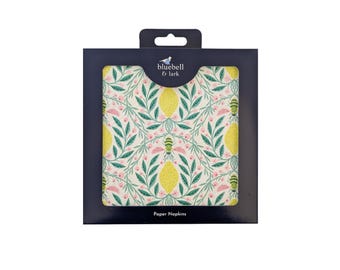 May include: A package of paper napkins with a lemon and floral design. The napkins feature a cream background with yellow lemons, green leaves, and pink flowers. The package is dark blue with the text "bluebell & lark" and "Paper Napkins".