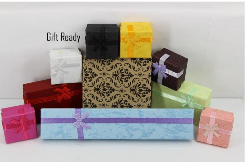 May include: A collection of various square and rectangular gift boxes in colors including black, yellow, white, red, dark brown, light green, pink, and magenta, with a long light blue box in front. The text Gift Ready is visible.