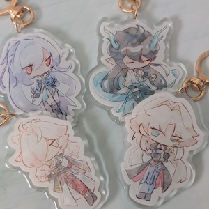 May include: Four acrylic keychains featuring anime-style character illustrations. Each keychain has a gold-colored clasp. The characters have various hair colors, including white, black, and blonde, and wear detailed outfits in shades of blue, red, and white.