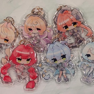 May include: Seven anime-style acrylic keychains featuring chibi characters with various hair colors, including blonde, red, and blue. Each keychain has a gold-colored keyring attached.