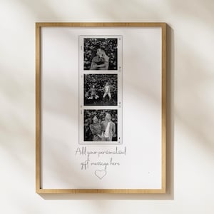 May include: A framed print with a light wood frame. The print features three black and white film strip style photos of people. Below the photos is the text "Add your personalised gift message here" with a heart symbol.