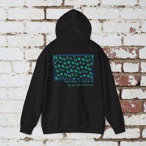 May include: Black hooded sweatshirt with a blue and green graphic print of lips and the text "Inspired start to climb into the sky and light up the world".