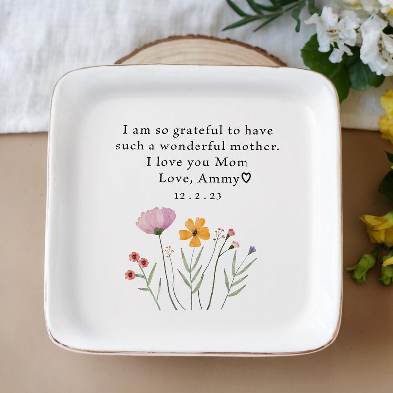 Puede incluir: Bandeja de cer&aacute;mica blanca con borde dorado, con un dise&ntilde;o floral y el texto "I am so grateful to have such a wonderful mother. I love you Mom Love, Ammy♡ 12.2.23"