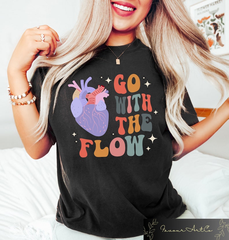 May include: Black t-shirt with a colorful graphic of a heart and the text "GO WITH THE FLOW" in a retro font.