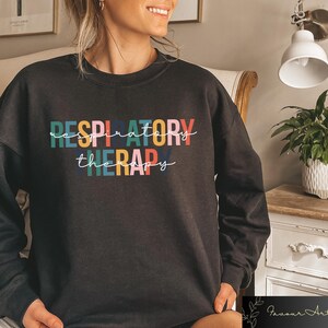 May include: Black sweatshirt with the text "RESPIRATORY THERAPY" in colorful letters.