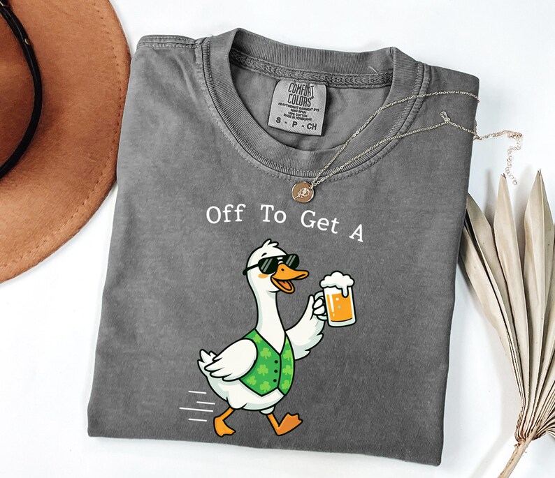 May include: A gray t-shirt with the text "Off To Get A" above a cartoon goose wearing sunglasses and a green vest, holding a beer. The goose is walking with motion lines.