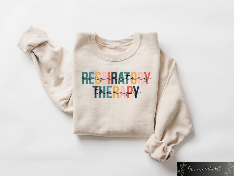 May include: A beige sweatshirt with the text "RESPIRATORY THERAPY" printed in colorful letters. The letters are in different colors, including pink, orange, yellow, green, and blue.