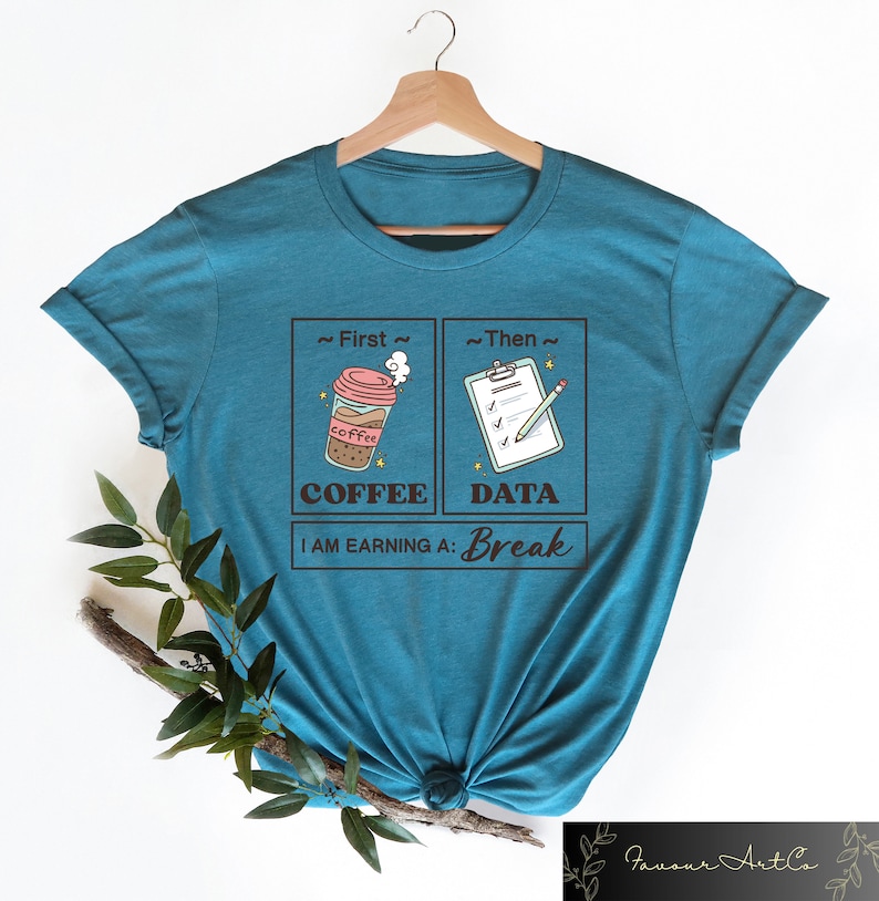 May include: Teal blue t-shirt with a graphic design of a coffee cup and a checklist with a pencil. The text reads "First Coffee, Then Data, I am earning a: Break".
