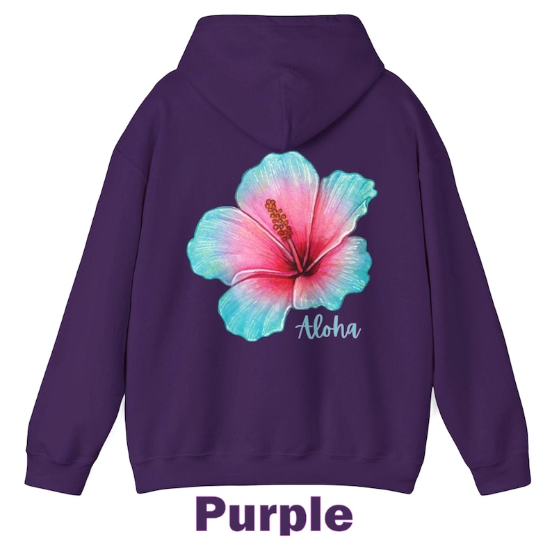 May include: A deep purple hooded sweatshirt featuring a large, vibrant hibiscus flower graphic on the back. The flower displays a gradient of pink and light blue petals with a yellow stamen. The word Aloha is printed in white script below the flower.