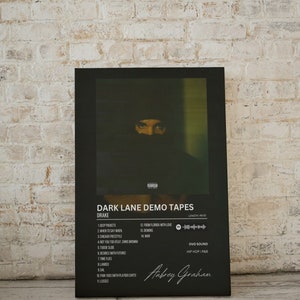 May include: Black and white album cover art for Drake's "Dark Lane Demo Tapes". The cover features a close-up of Drake's face, partially obscured by a black hood. The album title and tracklist are listed in white text on a black background. The album's length is 48:55. The album is by OVO Sound and is a hip hop and R&B album. The album cover is signed "Aubrey Graham".