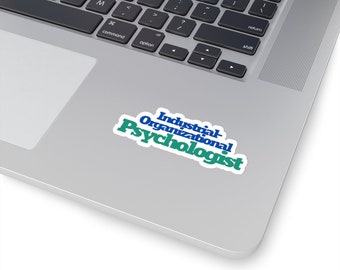 May include: A blue and green sticker with the text "Industrial-Organizational Psychologist" on a silver laptop.