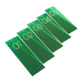 May include: Five green rectangular cards with white numbers from 01 to 05. The cards are arranged diagonally, with the numbers clearly visible. The cards have a glossy finish and are set against a white background.