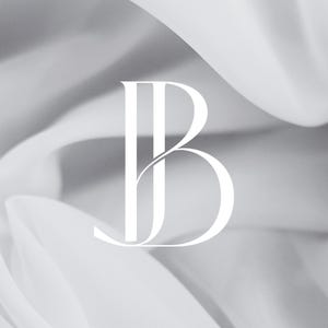 Könnte beinhalten: Elegantes weißes Monogramm-Logo mit den Buchstaben "JB" in einer stilisierten Serifen-Schriftart. Das Design ist vor einem Hintergrund aus weichem, fließendem, weißem Stoff platziert und erzeugt ein Gefühl von Luxus und Raffinesse. Die Gesamtästhetik ist sauber und modern.