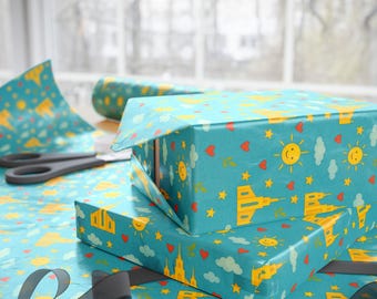May include: A stack of gift boxes wrapped in blue wrapping paper with a pattern of yellow suns, red hearts, white stars, and yellow buildings. The wrapping paper has a light blue background.