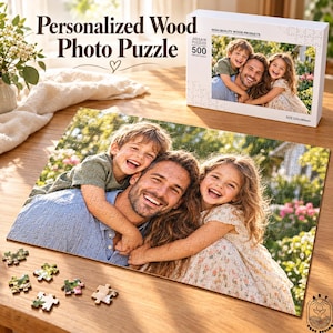 Puede incluir: Un rompecabezas de madera personalizado con una foto de un hombre sonriente con un niño y una niña. La caja del rompecabezas muestra la misma imagen con el texto Personalized Wood Photo Puzzle y 500 piezas. Varias piezas sueltas están sobre la mesa.