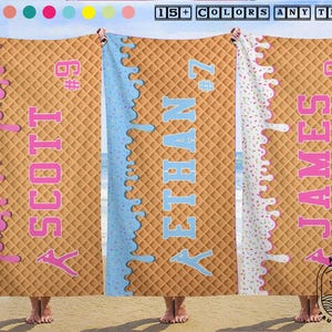 May include: Three beach towels with a waffle cone design. Each towel has a different colour of 'melted' ice cream dripping down the side, with a name and number printed in a contrasting colour. The towels are held up by people on a beach.