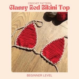 May include: A crochet bikini top with a red crochet body and a beige crochet trim. The top is laid out on a wooden surface. The text "Classy Red Bikini Top" is at the top of the image. The text "Beginner Level" is at the bottom of the image.