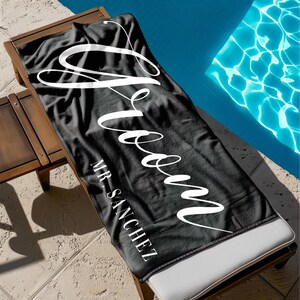 May include: Black beach towel with the word "Groom" written in white cursive script. The text "MR. SANCHEZ" is written in white below the word "Groom".