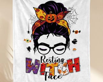 May include: White Halloween-themed blanket featuring a graphic of a woman with a messy bun, glasses, and the text "Resting Witch Face." The design includes pumpkins, spiders, and candy.