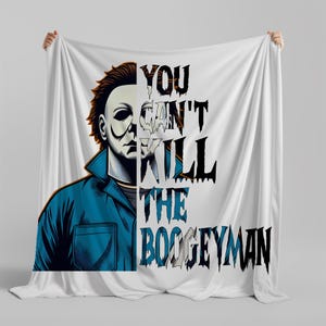 May include: White blanket featuring a graphic of Michael Myers from the Halloween movie franchise. The design includes a portrait of Myers and the text "YOU CAN'T KILL THE BOOGEYMAN" in black and white.