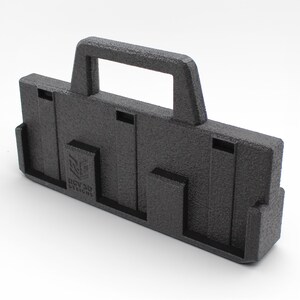 May include: A textured black 3D-printed carrying case with a handle. The case has a rectangular shape with several cut-out sections and the text "RGV 3D DESIGNS" on the front. The case is designed for carrying items.