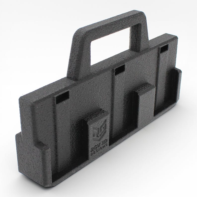May include: A black 3D-printed carrying case with a handle and multiple slots. The case has a textured surface and the text "RGV3D DESIGNS" is visible on the side. The design appears to be for holding or organizing items.