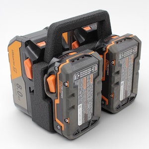 May include: A black and orange Lithium Ion battery pack with a handle. The pack has a capacity of 8.0 Ah. The battery pack is designed for power tools. The pack has a black and orange color scheme.