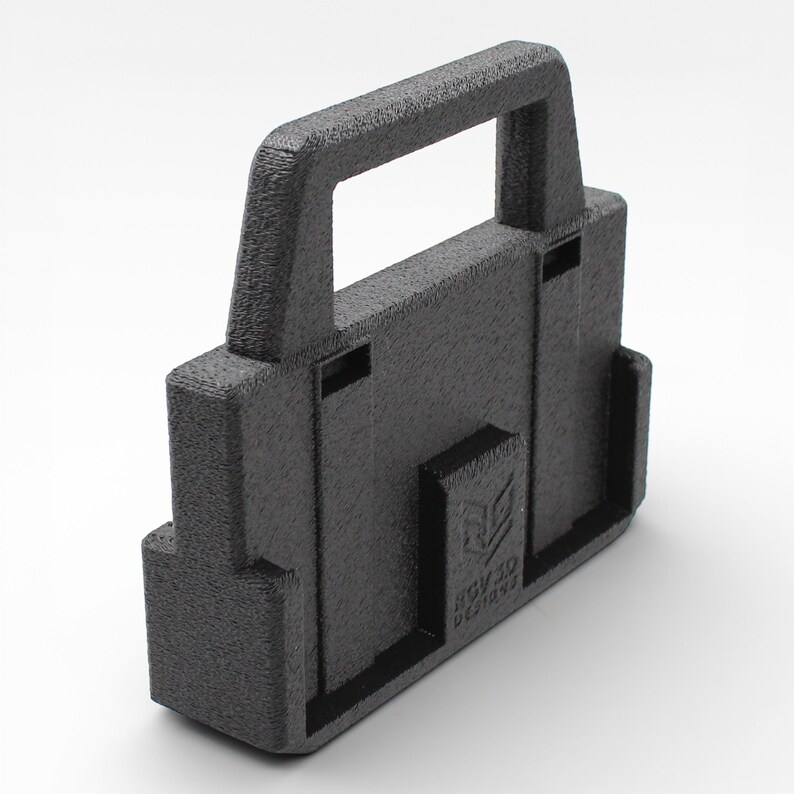 May include: A black, textured, rectangular object with a handle. The object has a boxy shape with a handle on top and a logo that reads "RGV 3D DESIGNS". The object appears to be 3D printed.