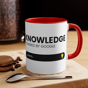 May include: White ceramic mug with a red rim and handle. The mug has the text "KNOWLEDGE POWERED BY GOOGLE" and a search bar with a lightbulb icon.