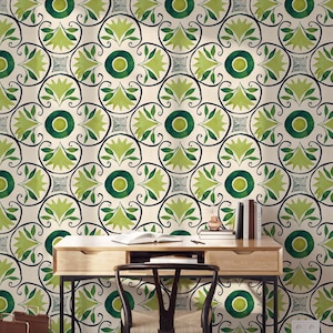 May include: A room featuring a desk and chair against a wall with a repeating green and cream floral pattern. The desk is made of wood and has a drawer. A magazine rack and books are also visible.