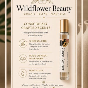 May include: A Wildflower Beauty Coco Amber roll-on perfume bottle with a gold cap. The label features a floral design and the words "Coco Amber." The product is described as organic, clean, and made with plant oils. The text also mentions it is chemical-free and made on Kauai.