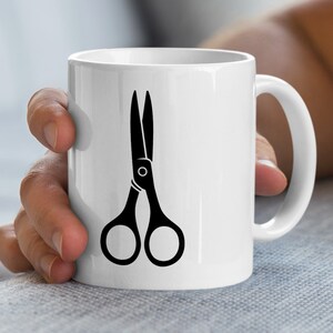 Könnte beinhalten: Weißer Keramikbecher mit einem schwarzen Scheren-Design. Die Schere ist in einer einfachen, kräftigen Kontur dargestellt. Der Becher hat einen Standardgriff und eine glatte, glänzende Oberfläche, geeignet für heiße oder kalte Getränke.