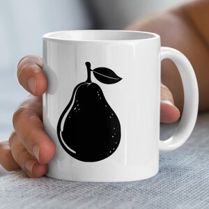 Könnte beinhalten: Weiße Keramiktasse mit einer schwarzen Birnenillustration. Das Birnendesign umfasst einen Stiel und ein Blatt. Die Tasse hat einen gebogenen Griff.