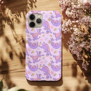 May include: A lavender phone case featuring a repeating pattern of purple dragons with pink accents, light bulbs, and star-shaped flowers. The case has a glossy finish and a camera cutout.