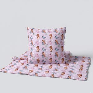 Peut inclure: Un ensemble de coussin et de couverture lavande avec un motif r&eacute;p&eacute;t&eacute; de personnages de dessins anim&eacute;s. Les personnages incluent une fille et un extraterrestre bleu. L'ensemble est con&ccedil;u pour une chambre d'enfant.
