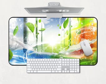 Könnte beinhalten: Ein Computer-Setup mit einem lebendigen Mauspad mit Naturmotiv, einer weißen Tastatur und einer passenden Maus. Das Mauspad zeigt eine farbenfrohe Illustration mit Wasser, Blättern und hellem Licht. Ein Monitor zeigt die Uhrzeit an.