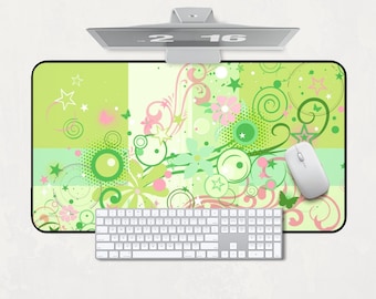Könnte beinhalten: Ein Computer-Setup mit einem lebendigen Mauspads mit einem Blumen- und Wirbeldesign in Grün-, Rosa- und Weißtönen. Eine weiße Tastatur und Maus sind auf dem Pad positioniert. Ein Monitor zeigt die Uhrzeit "2:16".