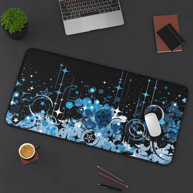 May include: A black and blue mouse pad with a design of stars, swirls, and white splatters on a black background.