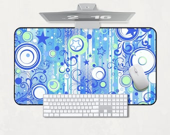 Könnte beinhalten: Rechteckiges Mauspad mit einem abstrakten blauen, weißen und grünen Design mit Kreisen, Sternen und Wirbeln. Eine weiße Tastatur und Maus befinden sich auf dem Pad. Ein Computermonitor befindet sich darüber.