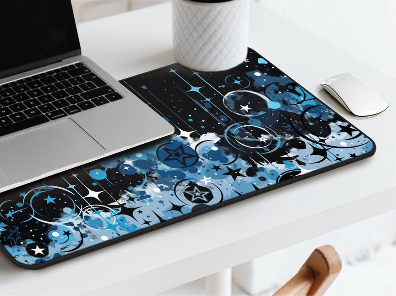 May include: A black and blue mouse pad with a design of stars, circles, and swirls. The design is abstract and has a watercolor effect.