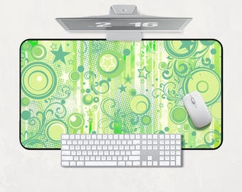 Könnte beinhalten: Computer-Setup mit einem grün-weiß gemusterten Mauspads, einer weißen Maus, Tastatur und einem Monitor. Das Mauspad hat ein Design aus Kreisen, Sternen und Wirbeln. Der Monitor zeigt die Uhrzeit 2:16 an.