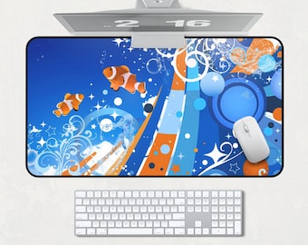 Könnte beinhalten: Eine Computermaus und -tastatur befinden sich unter einem Monitor. Das Mauspad hat einen blauen Hintergrund mit orangefarbenen und weißen Akzenten, Cartoon-Clownfischen und Blasen. Die Tastatur ist silberfarben.