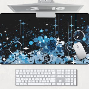 May include: A black and blue mouse pad with a design of stars, circles, and swirls. The mouse pad is on a white surface with a keyboard and a computer mouse.