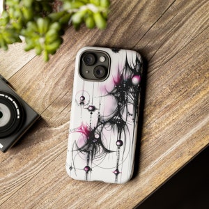 Op de afbeelding: Een witte telefoonhoes met een abstract ontwerp in zwart en roze. Het ontwerp bevat draaiende lijnen en cirkels met een roze en zwarte kleurstelling.