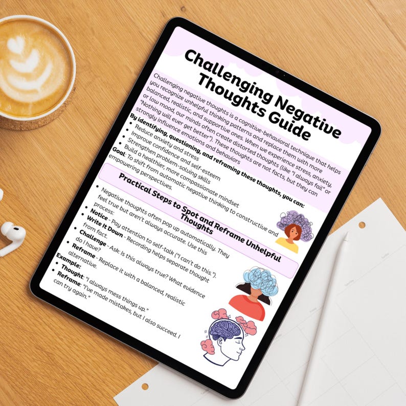 May include: A digital tablet displays a "Challenging Negative Thoughts Guide." The guide offers steps to spot and reframe unhelpful thoughts, with illustrations and bullet points. A cup of coffee and earbuds are on the wooden surface.
