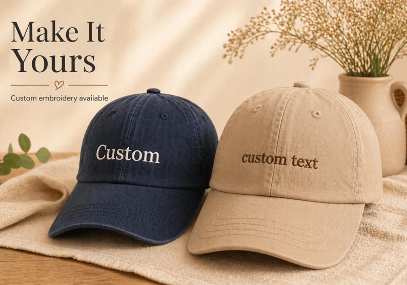 May include: Two baseball caps, one navy blue and one tan, are displayed. The navy cap has "Custom" embroidered in white, while the tan cap has "custom text" embroidered in a matching tan color. The image includes the text "Make It Yours" and "Custom embroidery available."