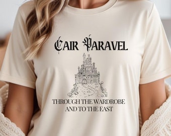 May include: A cream colored t-shirt with a black graphic of a castle and the text "Cair Paravel Through the Wardrobe and to the East."