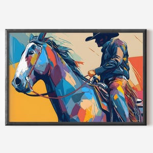 Op de afbeelding: Een ingelijste kunstdruk met een cowboy te paard. Het kunstwerk is in een kleurrijke, abstracte stijl met blauw, oranje en geel. De cowboy draagt een zwarte hoed en jas.