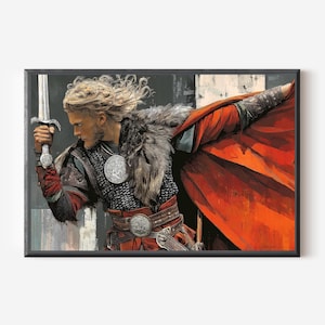 May include: A framed print of a Viking warrior holding a sword aloft. The artwork features the warrior in detailed armor, a fur-lined cloak, and a red cape. The background has a textured, abstract design.